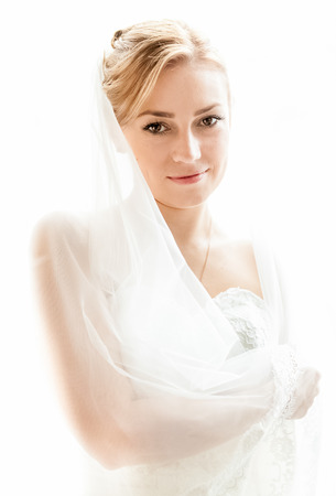 Isolated portrait of middle aged bride in white dress with long veilの写真素材