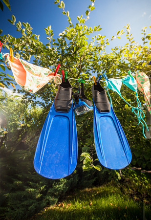 Outdoor shot of flippers and snorkeling mask drying on clotheslineの写真素材