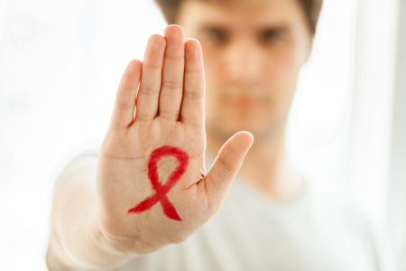 Portrait of young man holding arm in front f him with drawn red loopの写真素材