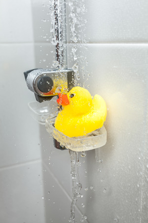 Closeup photo of yellow rubber duck on soap dish at showerの写真素材