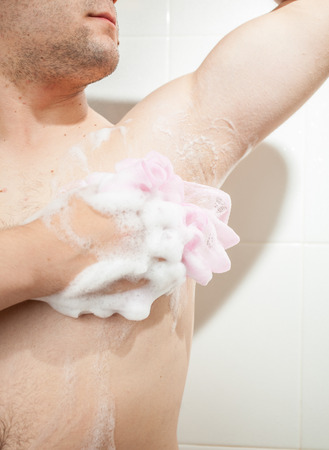 Closeup photo of young man washing armpit with spongeの写真素材