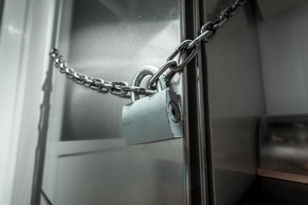 Closeup photo of refrigerator locked with chainの写真素材