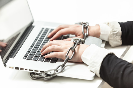 Photo of female locked to laptop by chainの写真素材