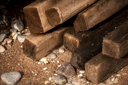Closeup shot of wet old wooden boards on sand beach with shells and stonesの写真素材