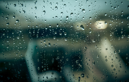 Photo of blurred building through window with raindrops
