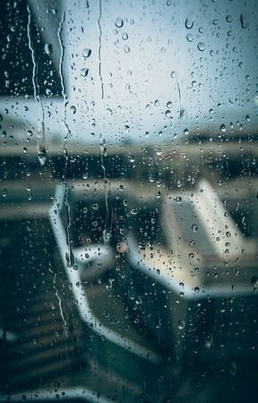 Closeup photo through window with drops at rainy dayの写真素材
