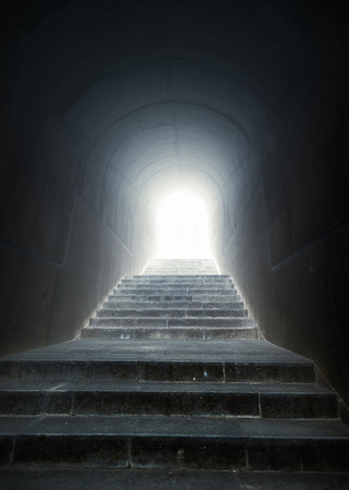 Conceptual shot of staircase in the tunnel with light at the endの写真素材