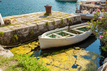 White wooden rowboat mooring at pier at sunny dayの写真素材