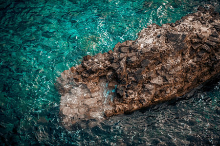 Beautiful view of big cliff in wavy turquoise seaの写真素材