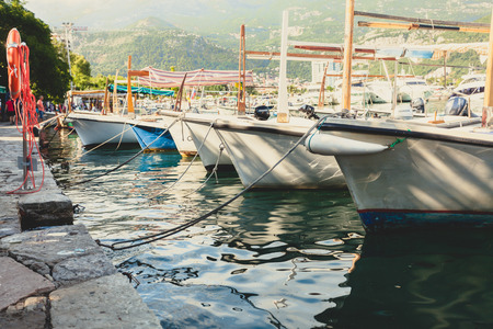 Toned photo of row of moored fishing boats at sunny dayの写真素材