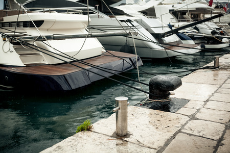Closeup photo of row of moored yachts at rainy dayの写真素材