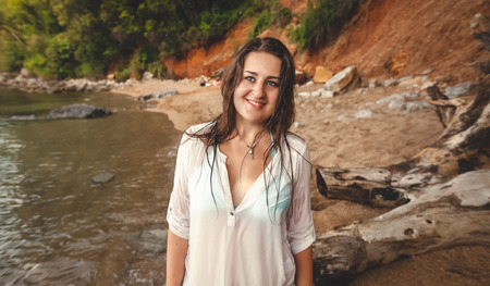 Closeup portrait of smiling brunette girl walking on sea beachの写真素材