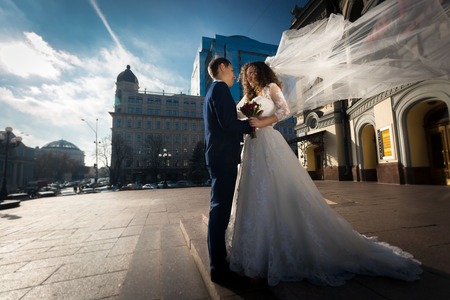 Beautiful elegant newly married couple hugging on streetの写真素材