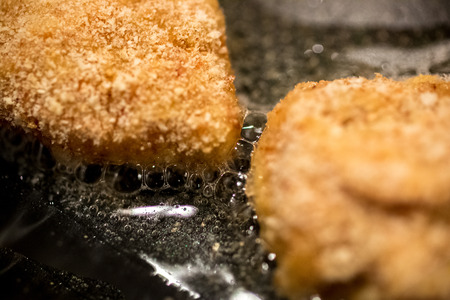 Closeup photo of chicken nuggets frying in hot oilの写真素材