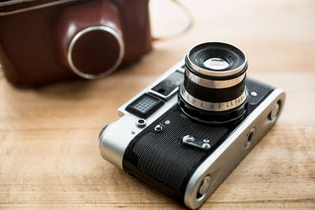 Macro photo of retro manual camera and leather case lying on tableの写真素材