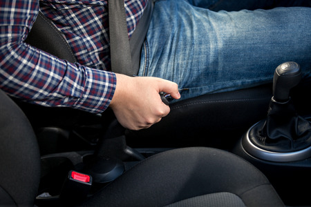Closeup of young man pulling handbrake lever in carの写真素材