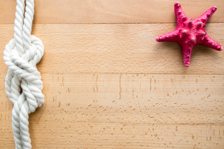 Horizontal sea travel frame with red starfish and marine knot over wooden boardsの写真素材