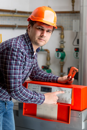 Portrait of engineer adjusting heating work on automated control dashboardの写真素材