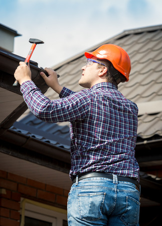Portrait of carpenter at work repairing house roofの写真素材
