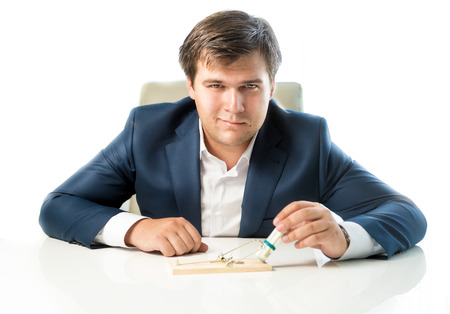 Portrait of cunning businessman putting money in trap as lureの写真素材