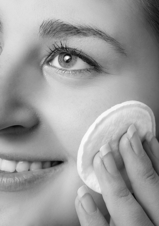 Closeup black and white portrait of beautiful woman removing makeupの写真素材