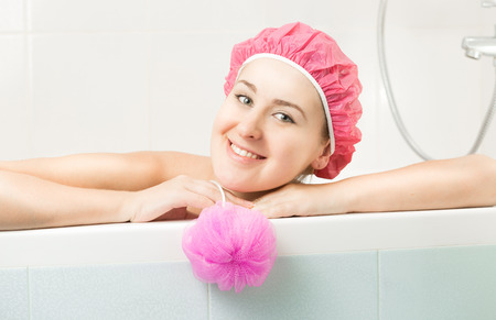 Closeup portrait of cute smiling woman posing in bathtubの写真素材