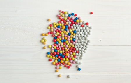 Closeup image of colorful and white candies in pile on white background. Concept of diversityの写真素材