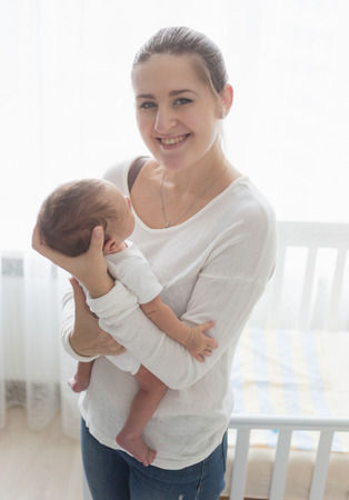 Toned portrait of happy smiling mother posing with her little babyの写真素材