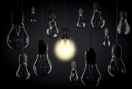 Hanging light bulbs on wires in dark roomの写真素材