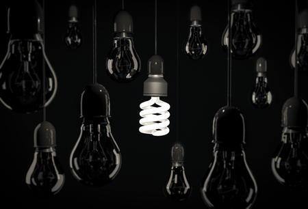 Eco energy saving bulb lighting incandescent bulbs hanging on wires over black backgroundの写真素材