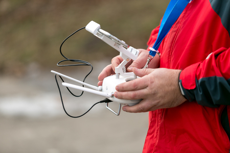 Closeup of man controlling drone from the transmitter outdoors