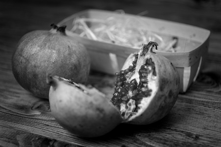 Black and white closeup photo of pomegranate cut in two halvesの写真素材