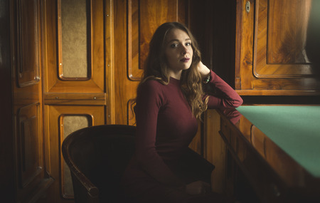 Toned portrait of elegant woman sitting behind old table at officeの写真素材