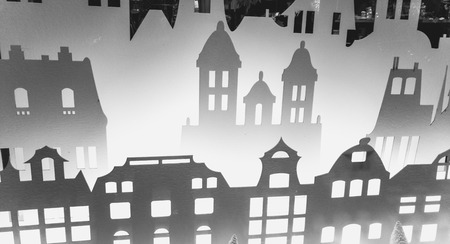Backlit silhouettes of old buildings made of paper