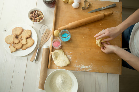 Toned photo of female hands making dough for holiday cookiesの写真素材