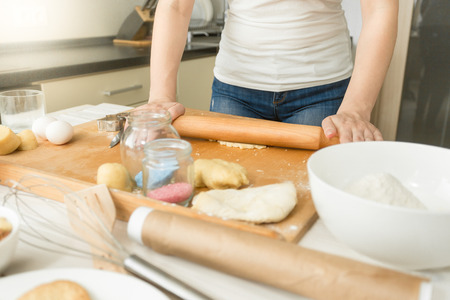 Closeup photo of woman making dough in kitchen