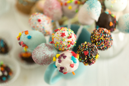 Cake pops decorated by colorful sprinkles on white background