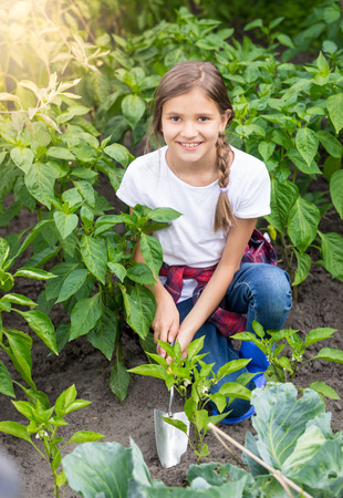 Beautiful teenage girl working at garden with hand shovelの写真素材