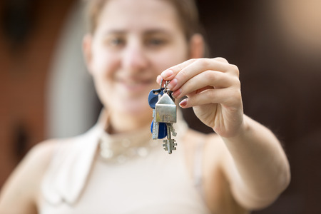 Closeup photo of young woman holding key from new houseの写真素材