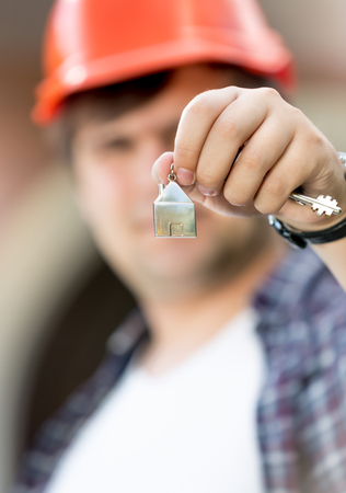 Closeup photo of foreman holding keys from new house in handの写真素材
