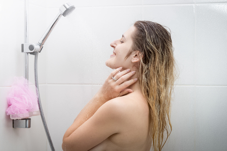 Beautiful woman with long hair enjoying showeringの写真素材