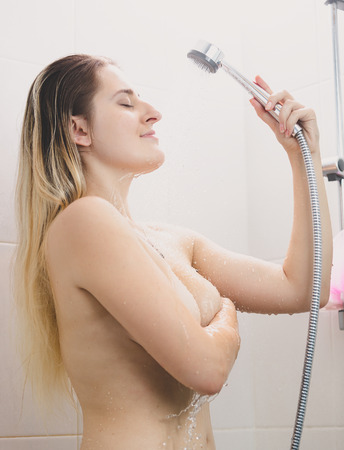 Portrait of sexy young woman with long hair washingの写真素材