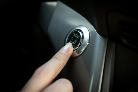 Closeup of driver starts the engine by pressing buttonの写真素材
