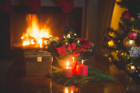 Christmas wreath with red candles in living room with burning fireplaceの写真素材