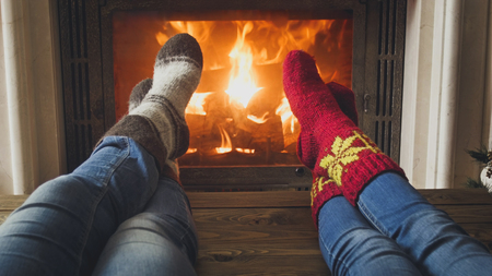 Closeup image of couple in jeans and wool socks lying by the fireplaceの写真素材