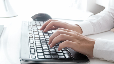 Closeup image of young businesswoman working on computer keyboardの写真素材