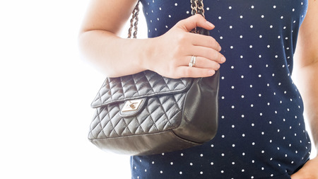 Closeup isolated photo of young woman with black leather pouchの写真素材