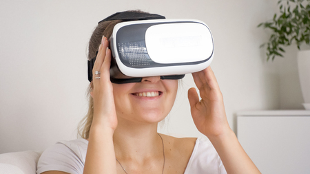 Portrait of smiling young woman with VR headset watching movies
