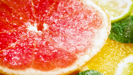 Macro photo of sugar falling on gjuicy cut grapfruitの写真素材