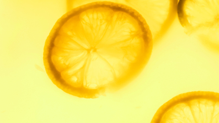 Abstract photo of lemon slices floating in juiceの写真素材